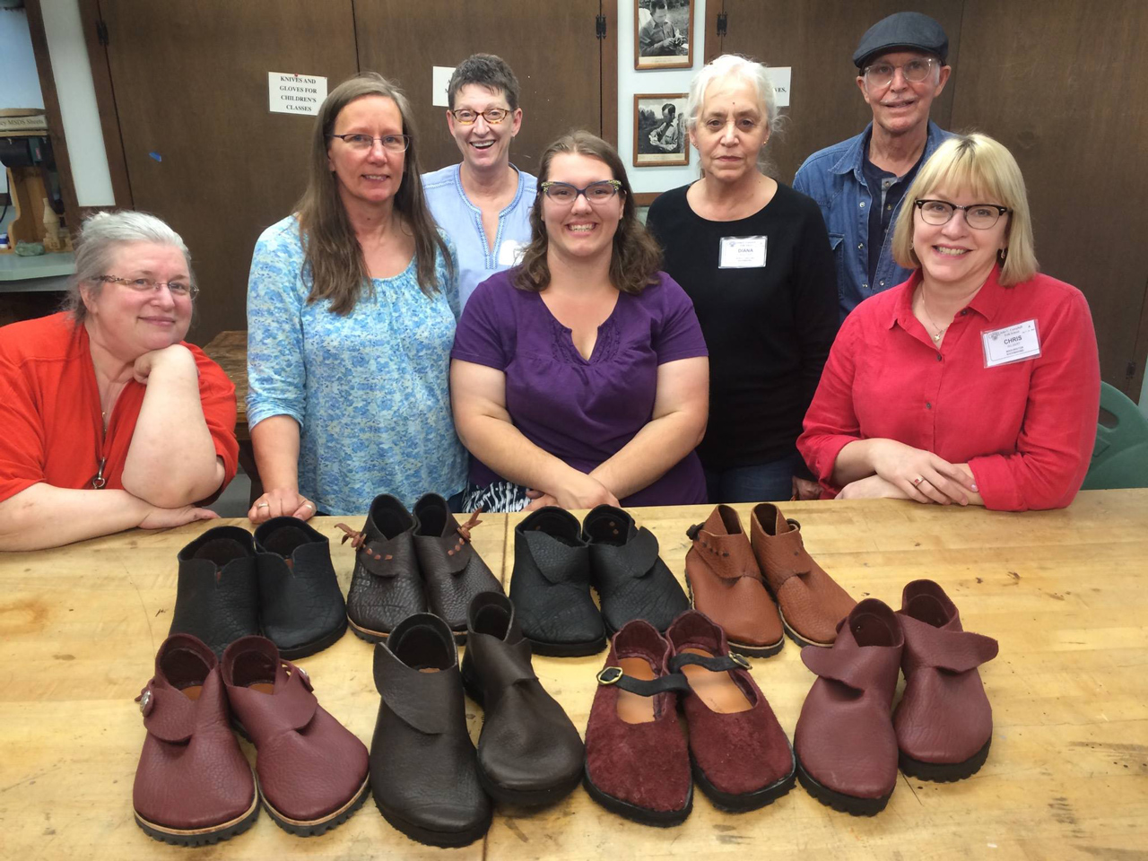 Group of students at the John C. Campbell Folk School with their completed shoe projects spread on a large worktable