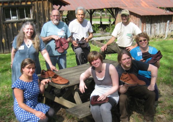 Group photo of students at John C. Campbell Folk School gathered around a picnik table with their newly made shoes
