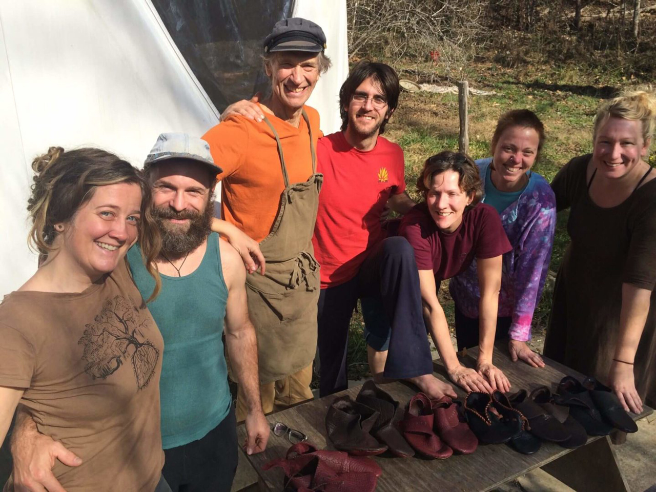 A shoemaking class at a North Carolina homestead with six students and their new shoes