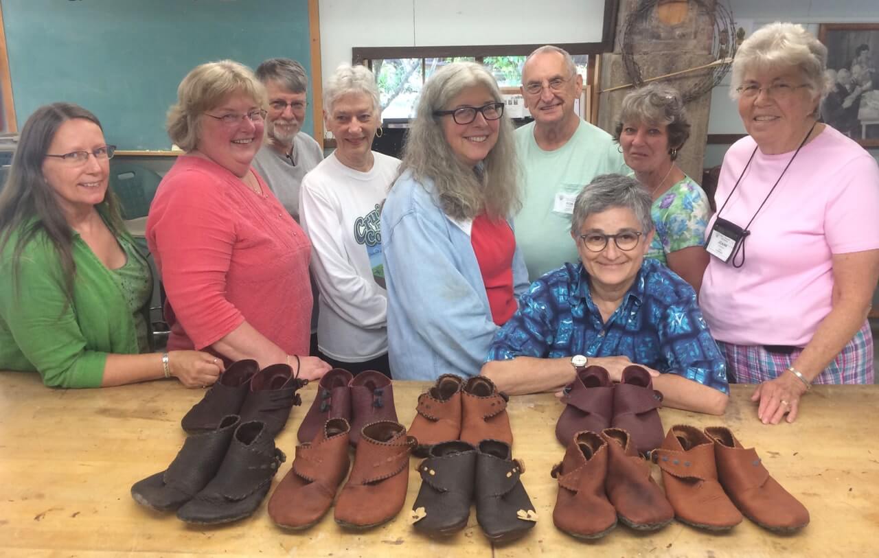 A group of happy shoemaking students at the John C. Campbell Folk School with their work product